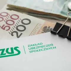 ZUS i pieniądze, być może na świadczenie mama 4 plus. Widoczne banknoty 200 i 500 zł, monety i spinacz biurowy.