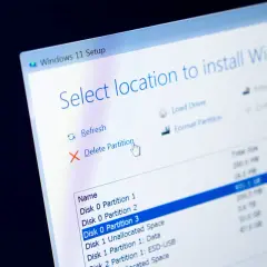 Instalacja Windows 11. Ekran wyboru lokalizacji, gdzie widać opcję "Usuń partycję". To nie jest defragmentacja dysku Windows 10, lecz przygotowanie do instalacji.