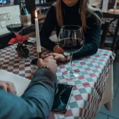 Para przy świecach, wino, dłonie splecione. Czy jemu na mnie zależy? Romantyczny wieczór w restauracji.