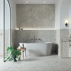 Modernes Badezimmer mit Terrazzo-Fliesen. Der Fliesentrend für Bäder zeigt sich hier in stilvoller Optik mit freistehender Wanne und Dusche.