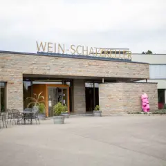 Die Genossenschaftskellerei Heilbronn lädt zu Veranstaltungen ein. Vor dem Gebäude steht eine pinke Gartenzwerg-Skulptur.