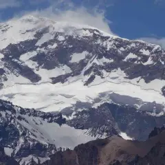 Aconcagua, najwyższy szczyt Ameryki Południowej, majestatycznie wznosi się w chmurach, pokryty śniegiem i lodem.