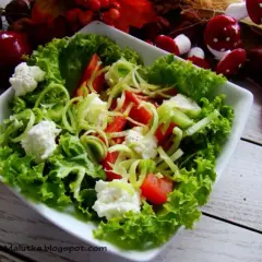 Sałatka z chrupiącą sałatą karbowaną, pomidorami i serem feta. Idealna na lekki posiłek.