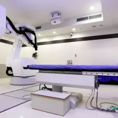 Ein CyberKnife-Behandlungsraum mit Roboterarm und Liege. Mögliche CyberKnife Nachteile sind die Kosten und die Notwendigkeit präziser Planung.