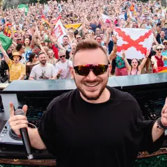 DJ Skytech rozkręca tłum na festiwalu, wśród flag Hiszpanii i Włoch.