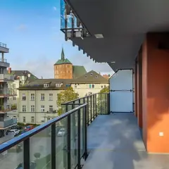Widok z balkonu na nowoczesne bloki i zabytkowe kamienice w Kołobrzegu. Pilnie sprzedam mieszkanie w tej okolicy!