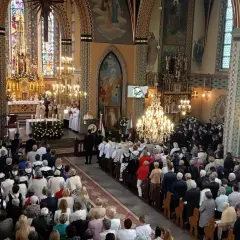 Uroczystość w kościele z wiernymi i duchownymi przy ołtarzu.