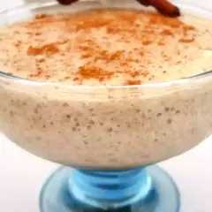 Un déliceux mousse banane crémeuse, saupoudrée de cannelle, servie dans un joli bol en verre bleu.