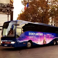 Un bus bleu "Disneyland Paris Express" circule dans Paris, prêt à emmener les visiteurs vers la magie.