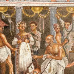 Starożytna mozaika: mężczyźni w togach, jeden z wieńcem laurowym, inny z brodą. Może to opowieść o tym, od czego pochodzi nazwa tragedia.