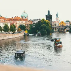Praga, Czechy. Widok na Wełtawę z łodziami i Mostem Karola. Ceny w Czechach mogą być zaskakująco przystępne, zwłaszcza poza sezonem.