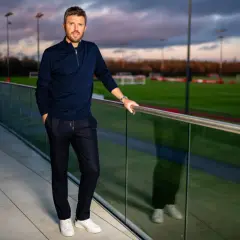 Michael Carrick, jeden z trenerów Man Utd, pozuje na tle boisk treningowych.