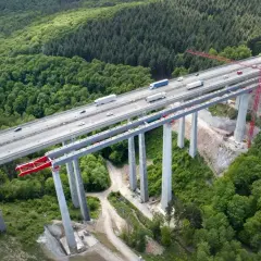 Most autostradowy w budowie, wsparty na filarach z betonu C30/37, otoczony lasem.