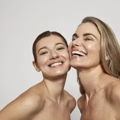 Dos mujeres sonríen, sus rostros radiantes y piel luminosa, un reflejo de la confianza que brinda Oslo Skin Lab.