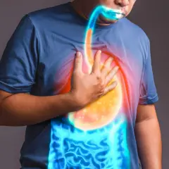 Uomo con mano sul petto, evidenziando il reflusso gastroesofageo e i sintomi legati all'ansia.