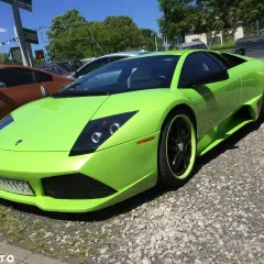 Jaskrawozielony Lamborghini Murcielago z czarnymi felgami i zielonymi akcentami stoi na żwirowym podjeździe.
