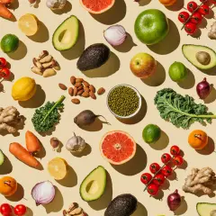 Bunte Vielfalt: Avocados, Karotten, Zitrusfrüchte, Nüsse und grünes Blattgemüse – ideal für eine gesunde Ernährung während der Schwangerschaft.