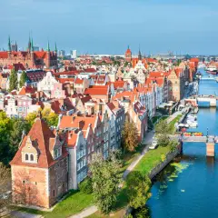 Widok na starówkę Gdańsk z kanałem Motławy, mostami i zabytkowymi kamienicami.