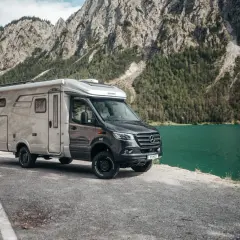Kamper Hymer na tle gór i jeziora. Zastanawiasz się, jakie prawo jazdy na kampera jest potrzebne, by wyruszyć w taką podróż?