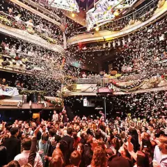Festa scatenata con coriandoli nella **discoteca Kapital di Madrid**. La folla esulta su più livelli, immersa in un'atmosfera di gioia e divertimento.