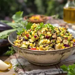Un délicieux caviar de courgettes, coloré et frais, garni de persil. Des aubergines et des citrons sont disposés autour.