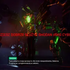 Potężny cyborg z zielonymi światłami i bronią groźnie patrzy na gracza. Tekst "BĘDZIESZ DOBRZE SŁUŻYĆ SHODAN JAKO CYBORG" sugeruje, że gracz stanie się częścią tej maszyny.