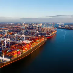 Großer Containerhafen mit Schiffen und Kränen. Die Einfuhr-Zollabfertigung ist hier ein wichtiger Prozess für den globalen Handel.