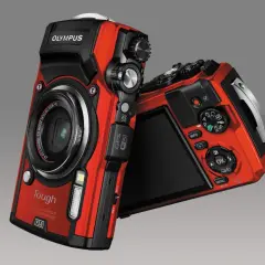 Dwa czerwone aparaty Olympus TG-5 leżą obok siebie. Jeden z nich jest skierowany przodem, drugi tyłem.