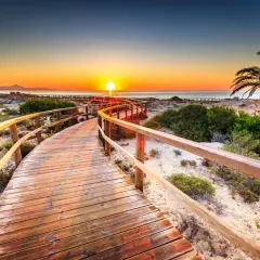 Drewniana ścieżka na plaży w Alicante o zachodzie słońca. Idealne miejsce na wakacje, sprawdź Alicante ceny!