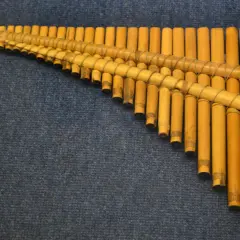 Drewniana fletnia pana instrument, wykonana z bambusowych rurek o różnej długości, związanych sznurkiem.