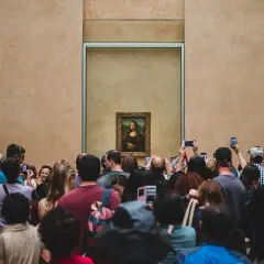 Menschenmassen drängen sich im Louvre, um die Mona Lisa zu sehen und zu fotografieren.