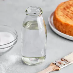 Zutaten für zuckersirup selber machen: Zucker, Wasser in Flasche, Pinsel und ein Kuchenboden.