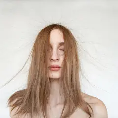 Frau mit langen Haaren, die elektrisch aufgeladen abstehen.
