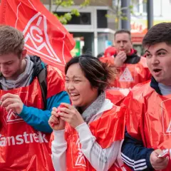 Junge Leute in roten Westen mit IG Metall Logo bei einer Demonstration. Sie wirken engagiert und hoffnungsvoll für die jav Wahlen.
