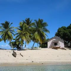 Piękna plaża z palmami i domkiem, idealne miejsce na wakacje. Zastanawiasz się, ile się leci na Madagaskar?