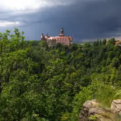 Zamek Książ góruje nad bujną zielenią, zapowiadając burzę. Widok z tarasu widokowego w Książańskim Parku Krajobrazowym.