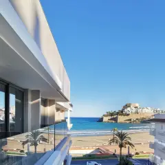 Vista desde el balcón de un hotel moderno hacia el mar y el histórico hotel castillo de Peñíscola.