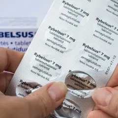 Dłonie trzymają opakowanie leku Rybelsus 7 mg, zawierającego tabletki z semaglutydem.