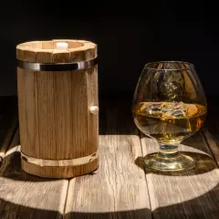 Mała beczka (quarter cask) i kieliszek whisky. Pokazuje skutki starzenia whisky w małych beczkach, przyspieszony proces.