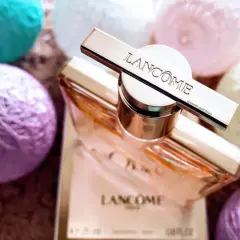 Elegancki flakon Lancome Idole 100ml otoczony pastelowymi kulkami.