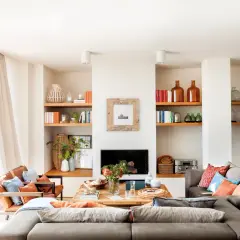 Ideas para un salón comedor acogedor con sofás grises, sillones de cuero, chimenea y estanterías llenas de libros y objetos decorativos.
