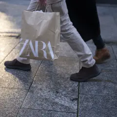 Osoba idzie z torbą z logo ZARA. Może to być efekt zakupów zrobionych przez aplikację ZARA.