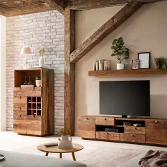 Rustikales Wohnzimmer mit Möbeln aus **Massivholz**, die Wärme und Gemütlichkeit ausstrahlen. Ein TV-Lowboard und ein Schrank mit Weinregal stehen im Fokus.