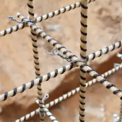 Siatka zbrojenia kompozytowego, wykonana z prętów z czarnymi spiralami, połączona drutem.