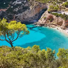 Una cala idílica con aguas turquesas y arena dorada, rodeada de acantilados y pinos. Un paraíso entre las mejores playas Comunidad Valenciana.