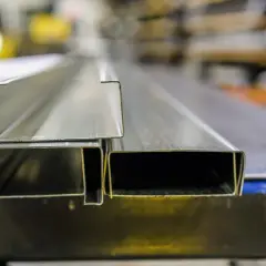 Dwa metalowe profile, jeden w kształcie litery L, drugi prostokątny, to kątowniki do płyt gk.