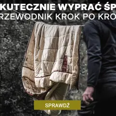 Jak prać śpiwór? Przewodnik krok po kroku. Śpiwór wisi na sznurku, obok stoi osoba w czarnej bluzie.