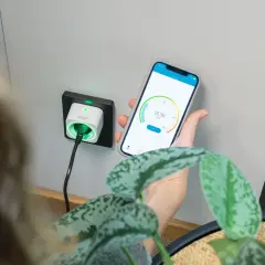 Smart eluttag med timerfunktion för lampor, styrd via mobilapp. Grön indikator visar att strömmen är på.