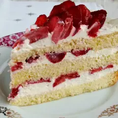Pyszny biszkopt z serkiem mascarpone i bitą śmietaną, przełożony truskawkami. Idealny deser na każdą okazję.