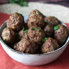 Succulente polpette in friggitrice ad aria, dorate e profumate, guarnite con prezzemolo fresco.
